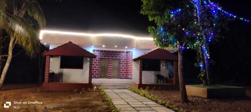 a house lit up at night with christmas lights at Garcinia Villa in Sirsi