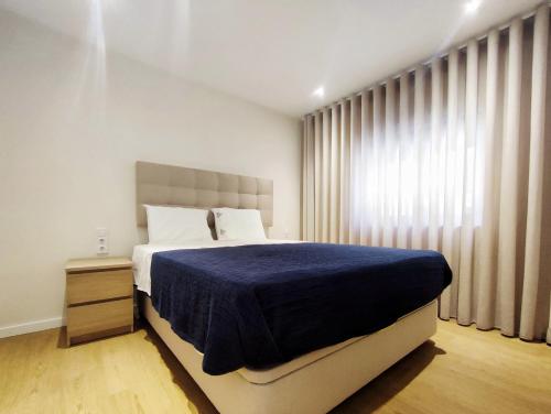 una camera da letto con un letto grande con una coperta blu di Casa Náutica T1 Sul a Ovar