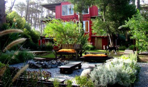 a garden in front of a red house at Cdl in José Ignacio