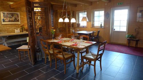 a dining room with a wooden table and chairs at Lilla Trulla Gårdshotell - Feels like home in Bolestad