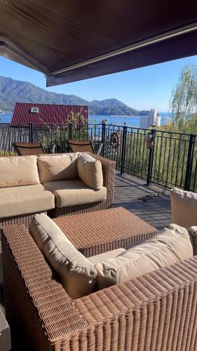 a patio with couches and chairs on a deck at ガーデンリゾート 潮美庵 in Hatsukaichi
