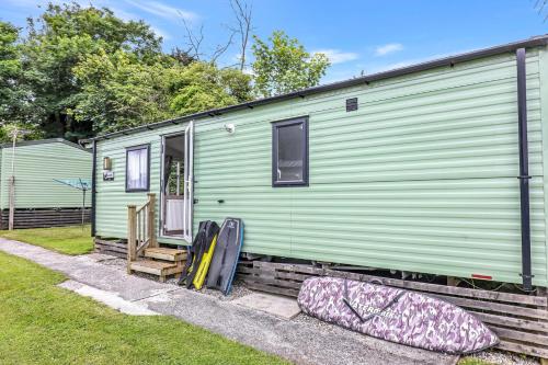 a green trailer with pillows in front of it at Tehidy Holiday Park in Illogan