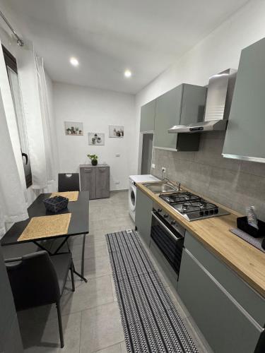 a kitchen with a stove and a table in it at La dimora delle rose in Noto