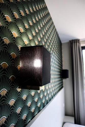 a wall with a green and white patterned wall at Auberge du château de Joux in La Cluse et Mijoux