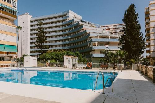 a swimming pool in front of a large building at Estudio en Torre del Mar a 3 minutos andando de la playa in Torre del Mar