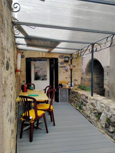 un patio avec une table et des chaises dans un bâtiment dans l'établissement La Bergerie, à Caux