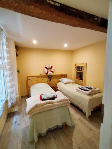 une chambre avec deux lits dans une pièce dans l'établissement La Bergerie, à Caux