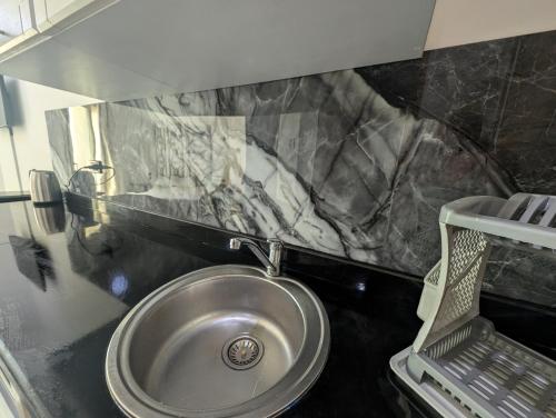 een badkamer met een roestvrijstalen wastafel en een spiegel bij Apartment in Hurghada direkt am Strand Kite Surfing in Hurghada