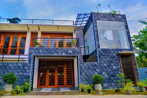 a house with a blue stone facade with a balcony at Kings Villa Galle in Galle