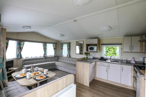 a kitchen and living room of a caravan at Tehidy Holiday Park in Illogan