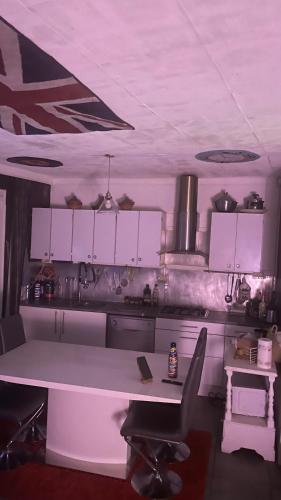 une cuisine avec des armoires blanches et une table et des chaises dans l'établissement Housse, à Avignon