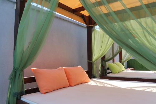 two beds in a room with green drapes at Holiday Park Verse in Ulcinj