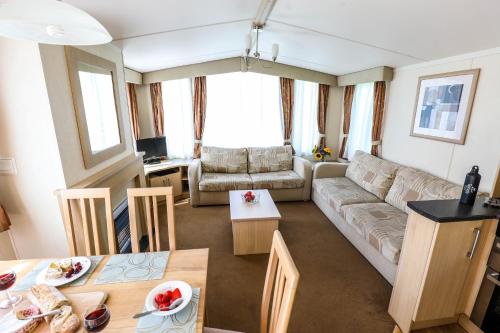 a living room with a couch and a table at Tehidy Holiday Park in Illogan