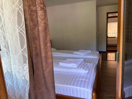 a bedroom with two beds and a curtain at Pensiunea Hanzu Darius in Gura Rîului