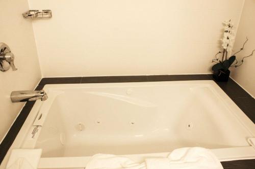 a white bath tub in a bathroom with a sink at Comfort Inn Ellensburg in Ellensburg