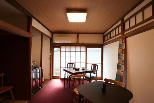 um quarto com uma mesa e cadeiras e uma janela em Hostel Hana An em Tóquio