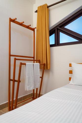 a bedroom with a bed and a mirror and a window at Vendol Lake Resort - Kandy in Kandy