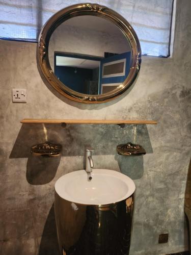 a bathroom with a sink and a mirror at Paje By Night Bungalows in Paje