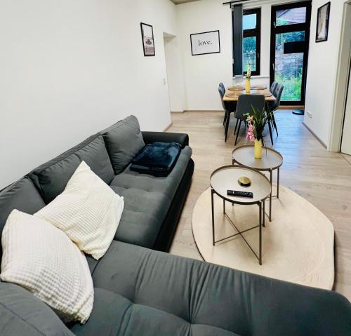 a living room with a couch and a table at SH-Apartments-Stylische FeWo Mia - Parken - Wifi in Schmalkalden