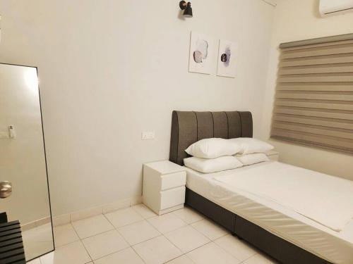 a bed with two pillows and a window in a room at IPOH MENGLEMBU LOHAS 4BR3Bath14 PAX in Ipoh