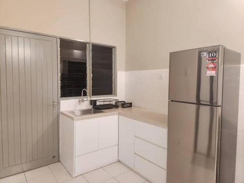 a kitchen with a stainless steel refrigerator and a sink at IPOH MENGLEMBU LOHAS 4BR3Bath14 PAX in Ipoh