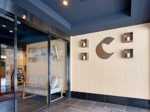 a room with a sign on a wall with a chair at Comfort Inn Kyoto Shijokarasuma in Kyoto