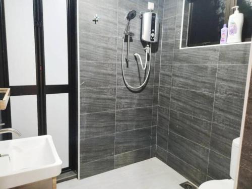 a bathroom with a shower and a sink at IPOH MENGLEMBU LOHAS 4BR3Bath14 PAX in Ipoh