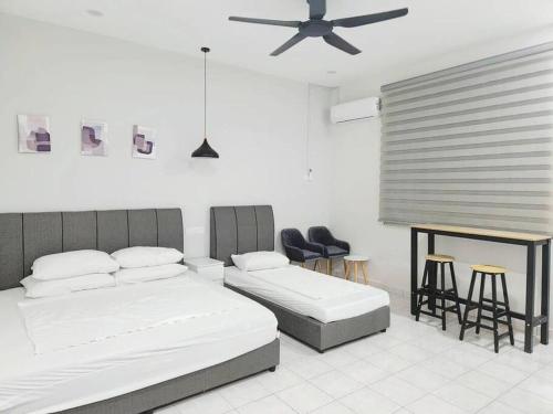 a bedroom with two beds and a table and chairs at IPOH MENGLEMBU LOHAS 4BR3Bath14 PAX in Ipoh