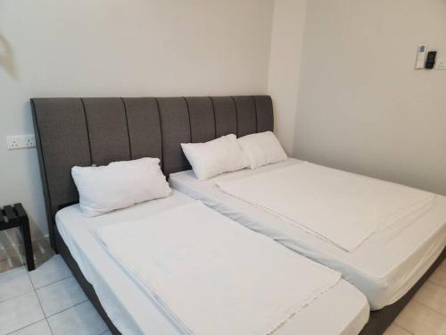 two beds sitting next to each other in a room at IPOH MENGLEMBU LOHAS 4BR3Bath14 PAX in Ipoh