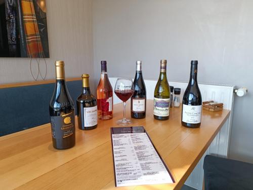 a group of wine bottles and a glass on a table at Auberge du château de Joux in La Cluse et Mijoux