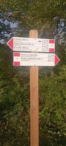 a wooden sign with street signs on it at Casa Luna in Monesiglio