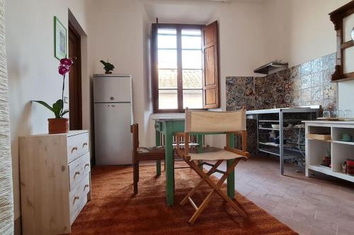 a kitchen with a green table and a refrigerator at Suite storica e panoramica - Centro in Pisa