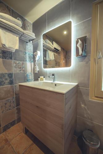 a bathroom with a sink and a mirror at Logis Hôtel Restaurant Le Plantevin in Propiac