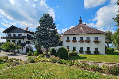 a large white house with a tree in the yard at Room in a Farm Residence Austria - Shared Bathroom in Iglbach