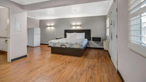 a bedroom with a bed and a wooden floor at Studio 6 Ontario CA Convention Center Airport in Ontario