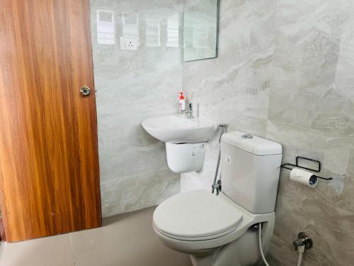 a bathroom with a toilet and a sink at Olive Serviced Apartments HSR Layout in Bangalore