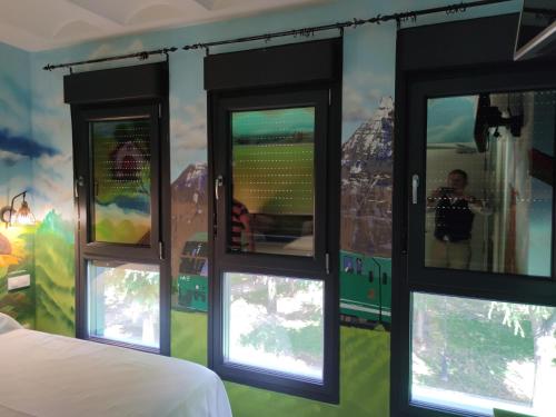 a bedroom with a mural of a train on the wall at FamilyHostelPinto in Pinto
