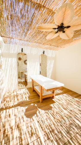 a room with a ceiling fan and a table at Ayvalık Sea Resort in Ayvalık