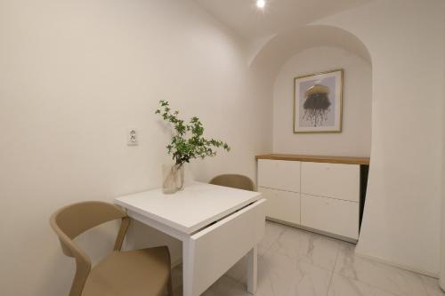 a white kitchen with a vase of flowers on a table at Tallinn City Apartments Old Town Toompea in Tallinn