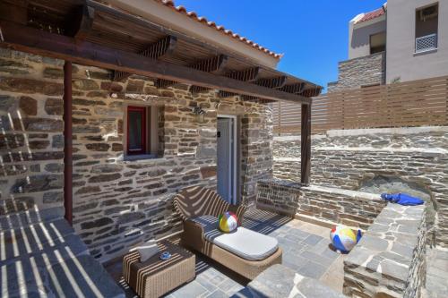 a stone house with a patio with a brick wall at KEOS by the sea in Korissia