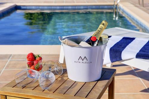 a bucket of wine and glasses next to a pool at Comeback LA CASA OCULTA DE LA LUNA in Salobreña