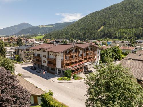 an aerial view of a town with a mountain at Alpenhotel Tirolerhof in Fulpmes