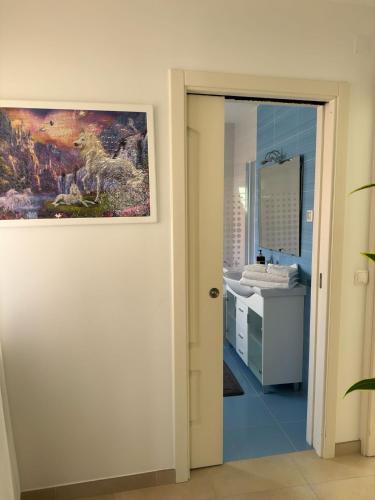 a bathroom with a sink and a painting on the wall at Ocean Breeze guesthouse in Nazaré