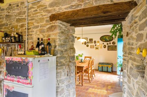 a kitchen and dining room with a stone wall at Casa Luna in Monesiglio