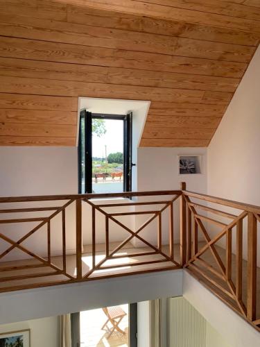 a staircase in a house with a wooden ceiling at Les écuries du Nevez in Plonéour-Lanvern