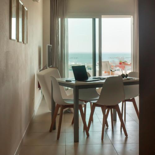 a dining room with a table with a laptop on it at Residence Millecento in Cesenatico