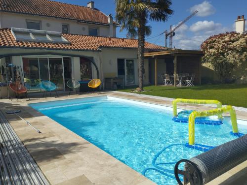 une piscine avec un toboggan aquatique dans une maison dans l'établissement Grande maison proche Nantes piscine chauffée couverte, à Vertou
