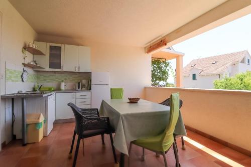 a kitchen and dining room with a table and chairs at Apartments Panda in Bol