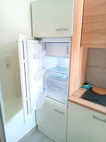 an empty refrigerator with its door open in a kitchen at Apartments Romantic and Family Room Zemlinski in Payerbach
