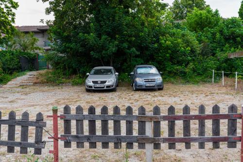 two cars parked in a yard behind a fence at iVAVev IS US ByTheSea EforieSud in Eforie Sud